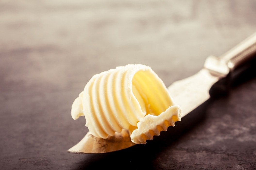 Butter on a Knife on Top of a Wooden Table