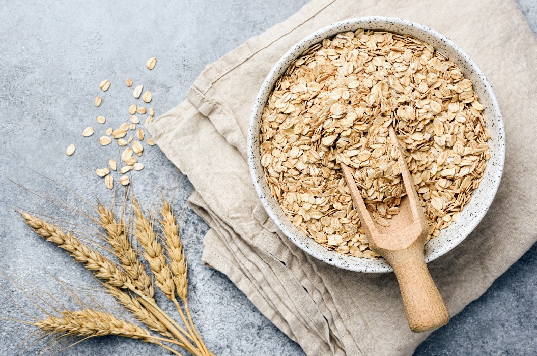 Oat flakes, oats or rolled oats in bowl. Table top view